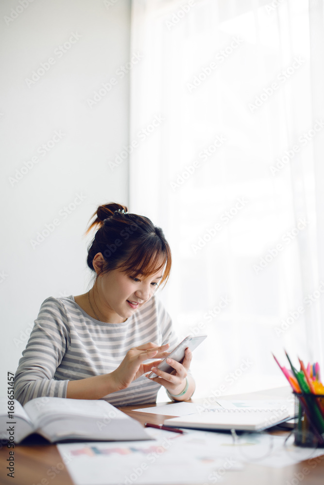 Beautiful Asia woman using her smartphone at home