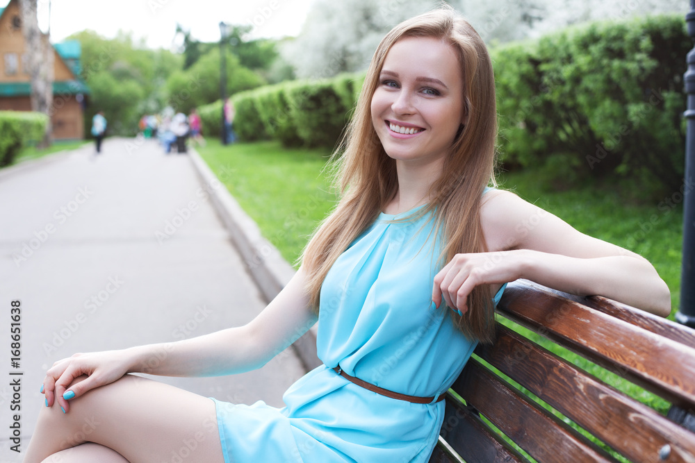 girl sitting on a bench in the park girl sitting on a bench in the park