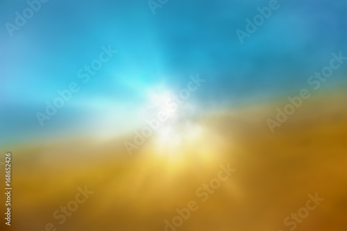 sun with light rays in blue sky with clouds blurred image