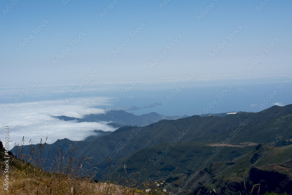 View above the clouds of volcanic mountains and sea at the peak of the aireiro, madeira