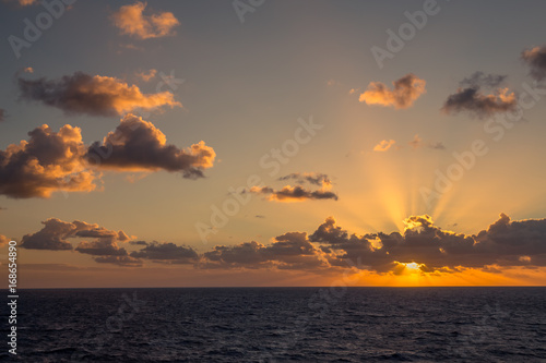 Sunset and dramatic set of clouds drifting over the tropical waters of the Caribbean Sea are lit by the last moments of daylight. © Paulo