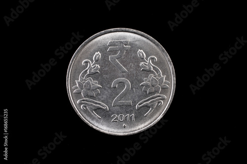 An extreme close up of an Indian two rupee coin on a solid black background
