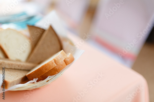 Sliced home made pieces of bread in the white plate. With text space photo