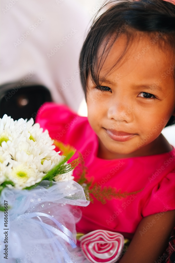Cute little girl in pink dress holding white flowers bouquet on wedding celebration. Little flower girl at wedding. Cute little girl in pink dress holding white flowers bouquet on wedding celebration. Little flower girl at wedding.