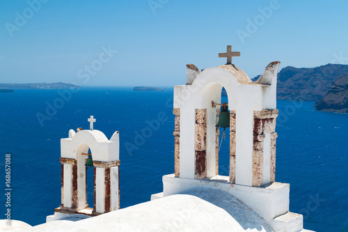 Bell tower of church above blue bay at Santorini,Greece