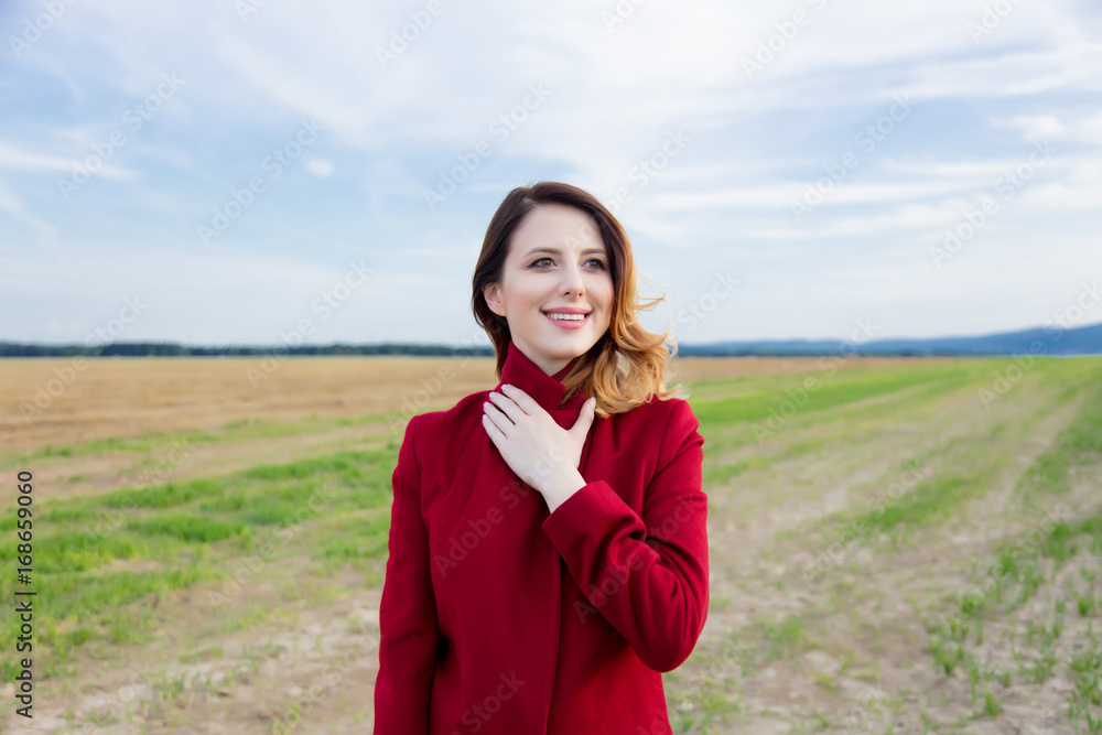 Woman in red coat at countryside field Woman in red coat at countryside field