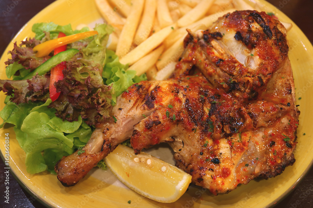 Flame grilled spicy chicken with chips and fresh salad Flame grilled spicy chicken with chips and fresh salad