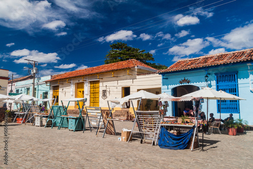 Vászonkép CAMAGUEY, CUBA - JAN 25, 2016: Colorful houses and souvenir stalls at San Juan d