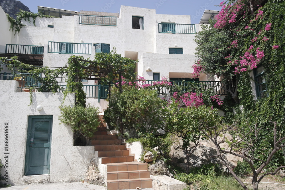 белый дом с цветущими деревьями в Греции