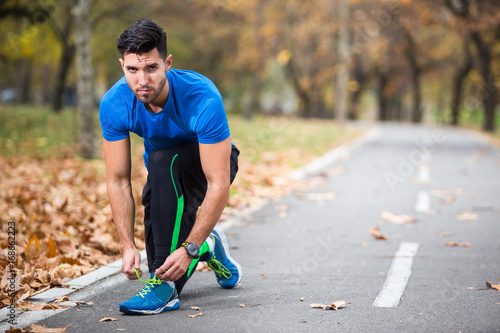Athletic young man tying laces.Running in the nature. Healthy lifestyle