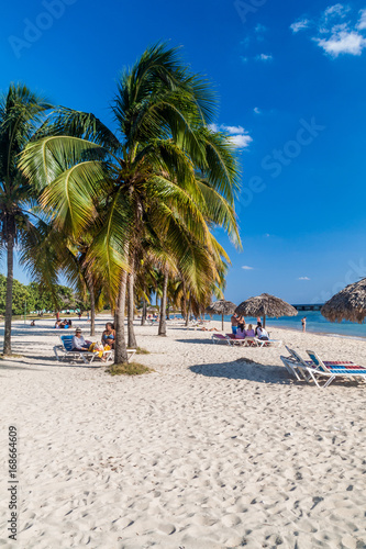 PLAYA GIRON, CUBA - FEB 14, 2016: Tourists at the beach Playa Giron, Cuba. This beach is famous for its role during the Bay of Pigs invasion. © Matyas Rehak