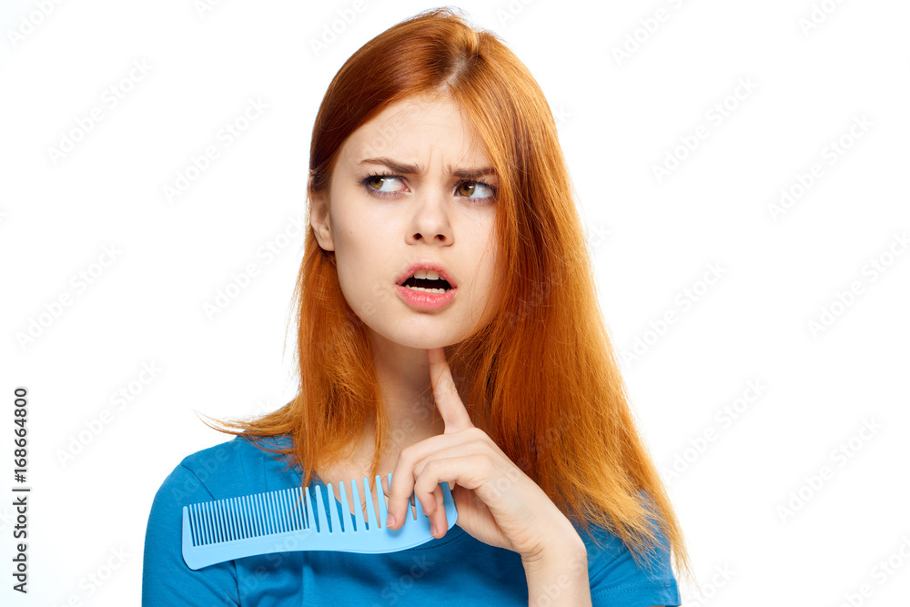 Beautiful woman on white isolated background holds a comb, portrait