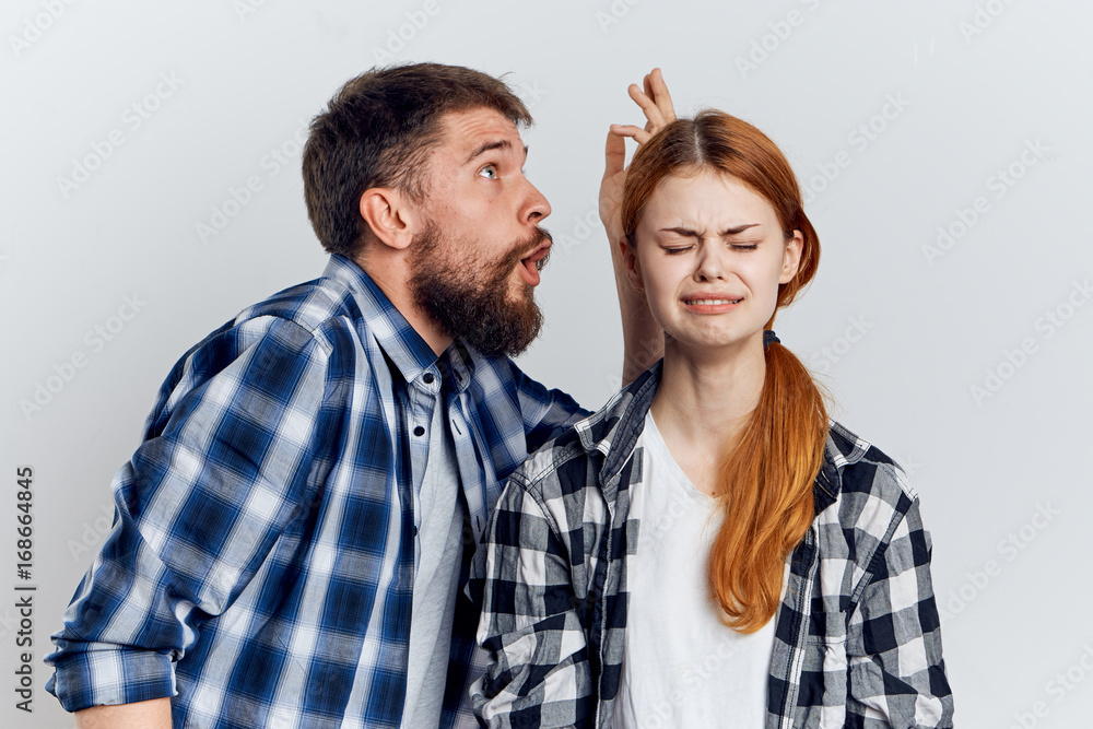 Beautiful woman on a light background and a bearded man, quarrel, emotions, attitude Beautiful woman on a light background and a bearded man, quarrel, emotions, attitude