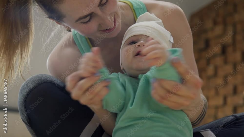Young woman playing with baby sitting on floor indoors. Family, love ...