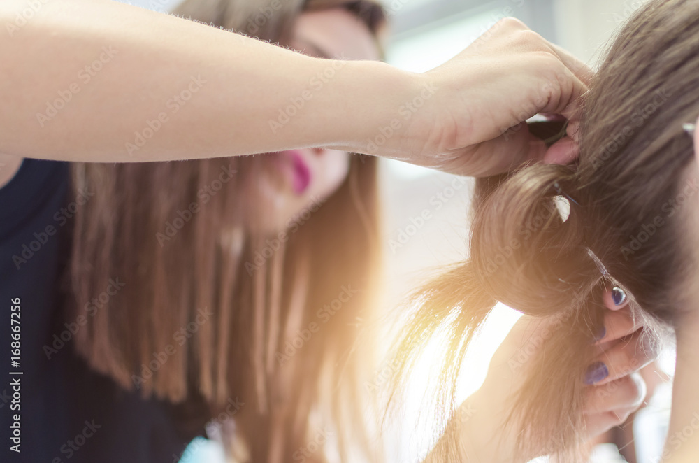 Fototapeta premium Hairdresser coiffeur makes hairstyle.