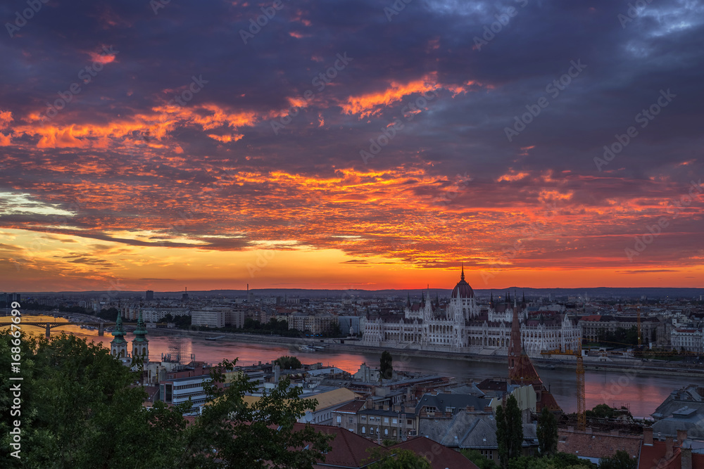 Fototapeta premium Budapest, Hungary - Dramatic colorful clouds and sunrise over Budapest and the Hungarian Parliament