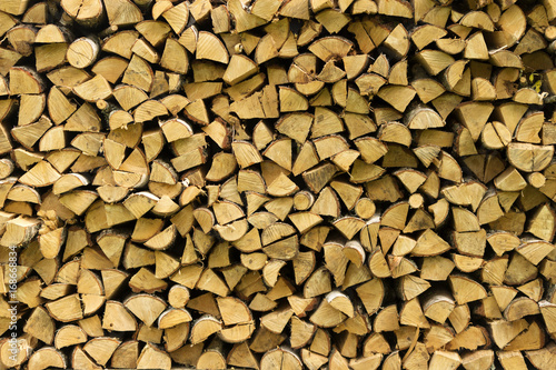 Wooden logs, beams, firewood, frame. A lot of wood. Wooden log wooden background. Fuel. Harvesting firewood for the winter. Logging.