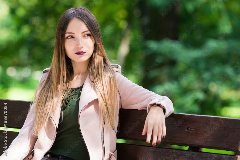 Portrait of informal fashionable girl on bench in park Portrait of informal fashionable girl on bench in park