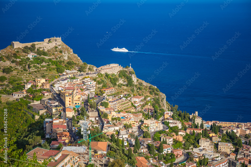 Panoramic view of small Village of Castelmola, overlooking town of Taormina with sea background, Sicily island, Italy