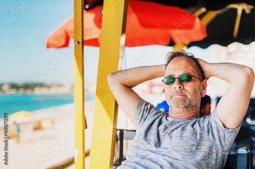 Handsome man resting at seaside beach restaurant photo