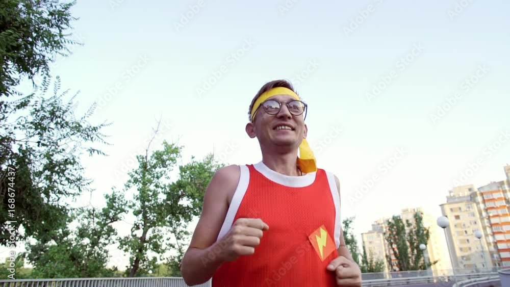 Funny thin guy in sports clothes jogging on the bridge in the morning. Funny thin guy in sports clothes jogging on the bridge in the morning.