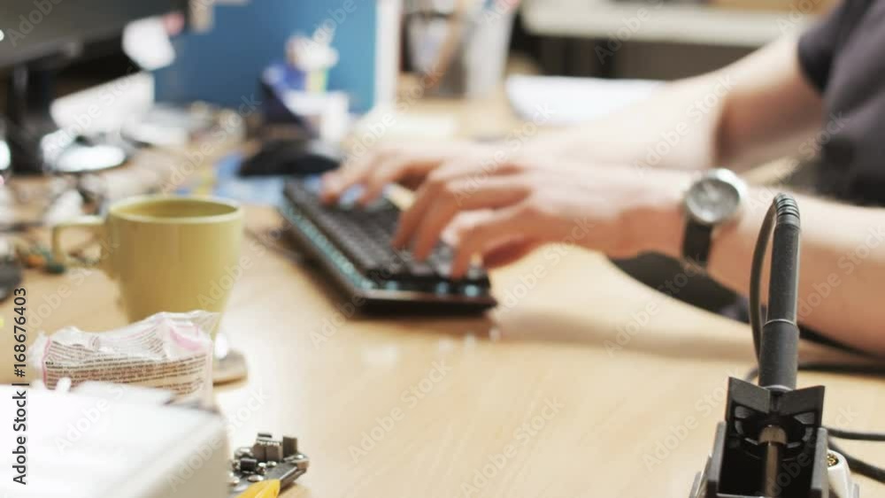 Young Man Typing on the Keyboard. Mess on the Desk Young Man Typing on the Keyboard. Mess on the Desk
