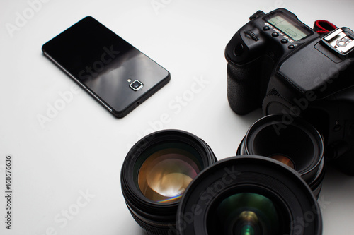 group of camera lenses and a mobile phone on a white background