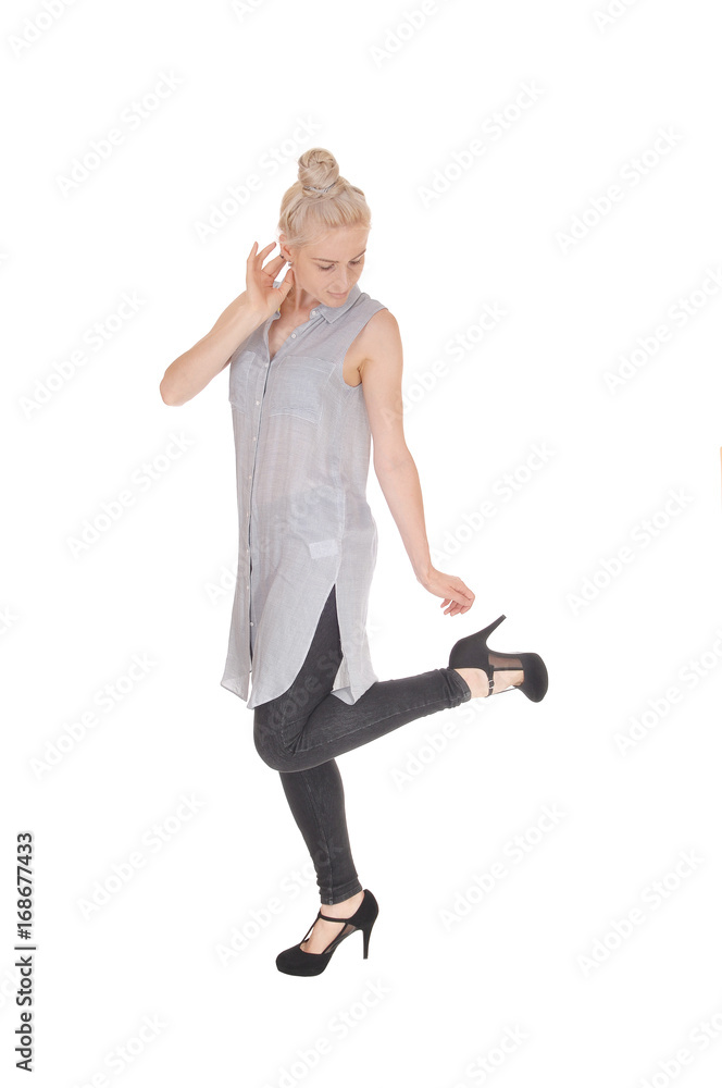 Slim woman standing in profile looking at heel Slim woman standing in profile looking at heel