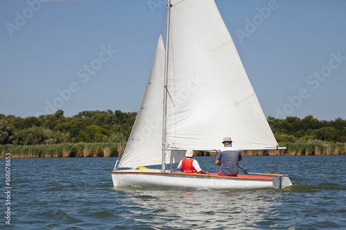 Two man drive a sport sailing yacht in competition