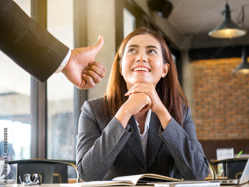 Φωτογραφία Boss/employer admires to young Asian businesswoman/staff/employee with smiling face for her success and good/best in work