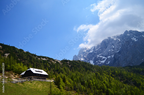 House in the green mountain in a sunny day with blue sky, Alps
