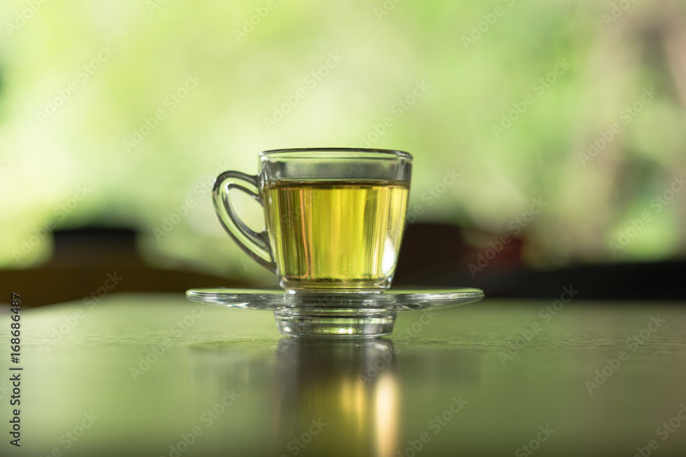 small teacup with tea placed on saucer. blur background. this image for drink,food,beverage concept small teacup with tea placed on saucer. blur background. this image for drink,food,beverage concept