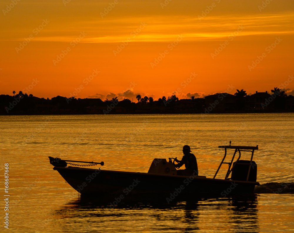 Sunset with the silhouette of a boat on the inter coastal in Belleair Bluffs, Florida