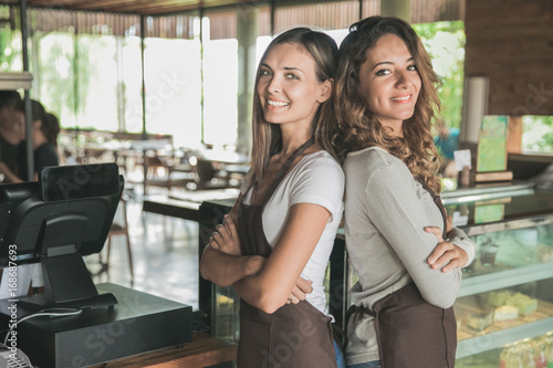 two beautiful female waitress smiling to camera