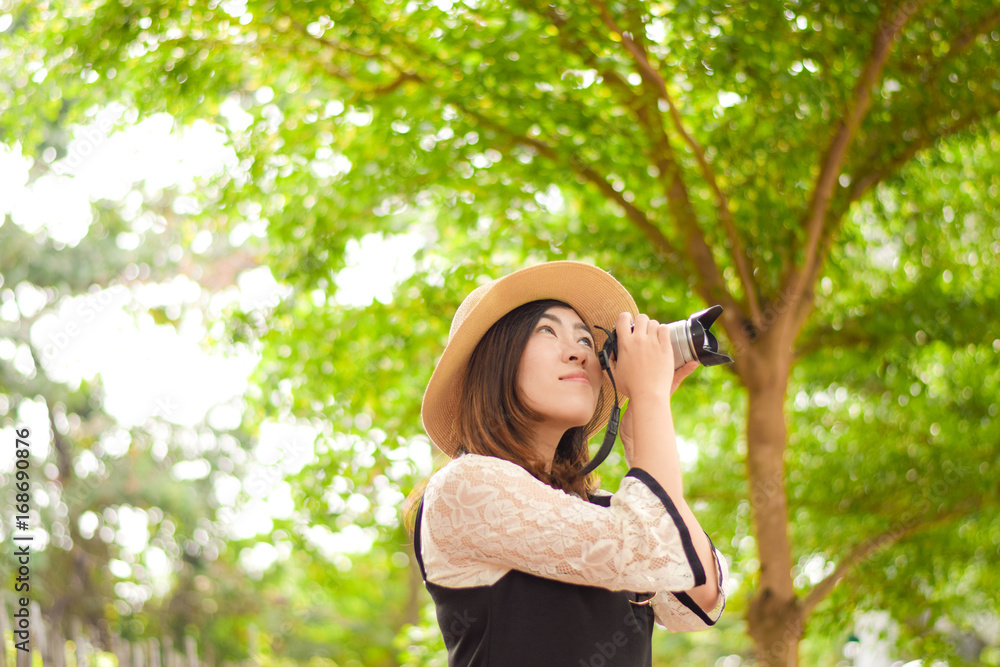 Young Asian woman is enjoy traveling into tropical forest and using mirror less camera. Young Asian woman is enjoy traveling into tropical forest and using mirror less camera.