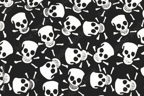 Color print on cotton fabric. White skulls and bones on a black background