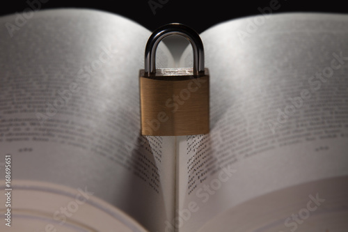 concept showing illiteracy dyslexia or learning difficulties with a lock blocking text in a book