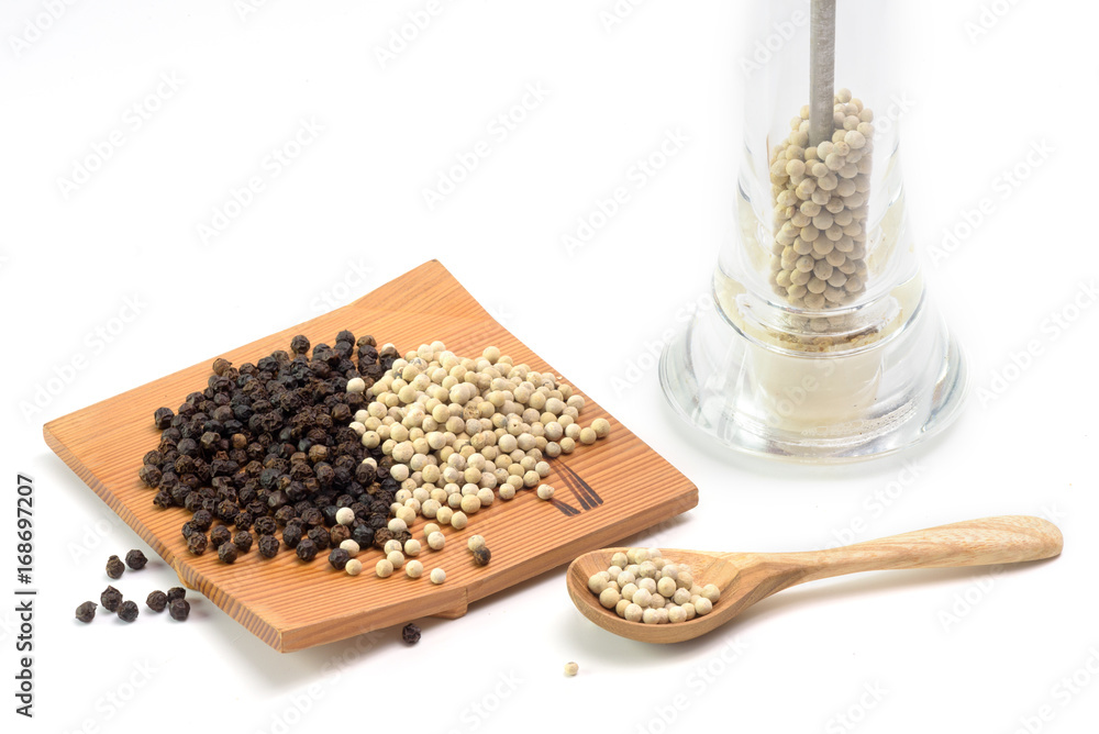 white and black pepper on wooden plate and white pepper in spoon on white background white and black pepper on wooden plate and white pepper in spoon on white background