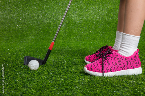 Closeup of a child golfer with putter and ball
