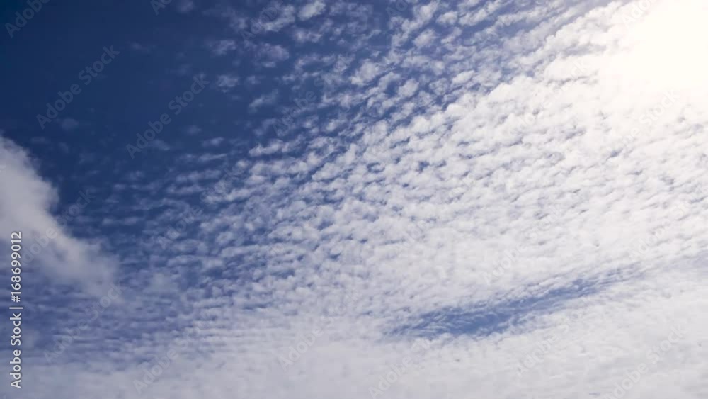 A time lapse of white clouds moving across a blue sky. A time lapse of white clouds moving across a blue sky.