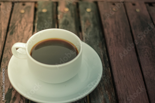 A white coffee cup on wooden table in the garden, Black coffee on wooden background, coffee break in the morning, relaxing and refreshing concepts.