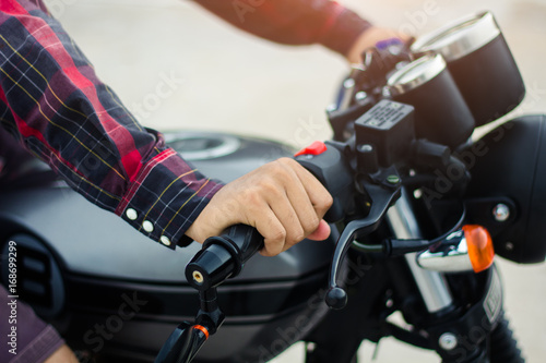 Closup hand  men wear a red plaid shirt, Drive a vintage motorcycle.