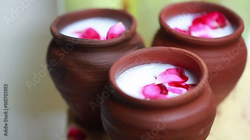 India milk with flowers in a clay pot.Milk for Indian gods photo