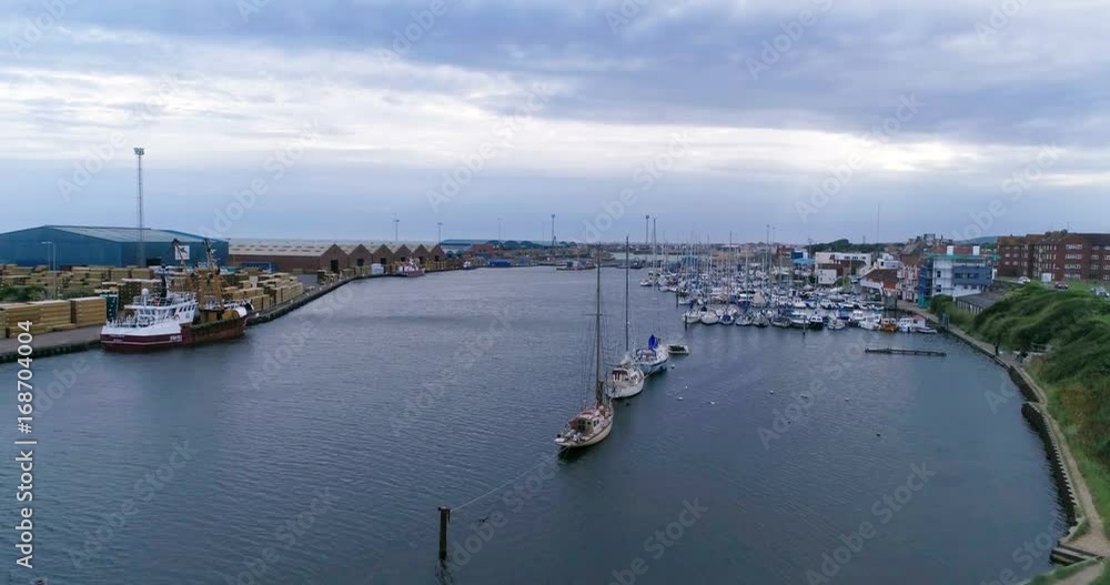 Aerial ascending view of sailing boats in a commercial harbor on a river mouth in Southern England Aerial ascending view of sailing boats in a commercial harbor on a river mouth in Southern England