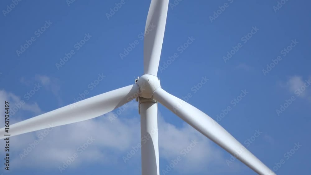 Wind turbine rotates blades against the background of sky. Close up Wind turbine rotates blades against the background of sky. Close up