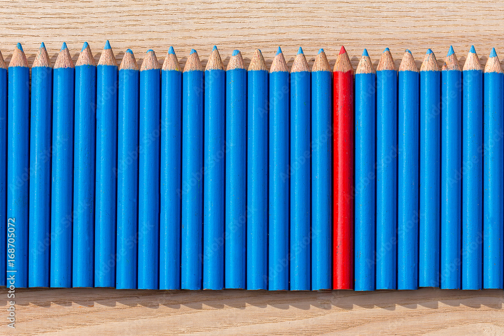 Des petits crayons de couleur bleu alignés avec un crayon rouge au milieu  Stock Photo | Adobe Stock