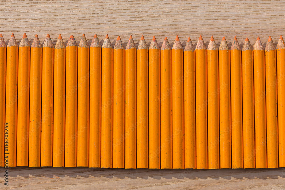 Des petits crayons de couleur orange alignés Des petits crayons de couleur orange alignés