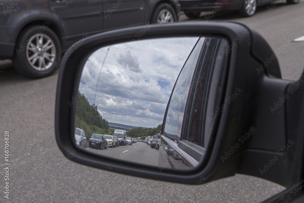 Trafficjam at autobahn Germany. Stopping traffic. Rear view mirror.