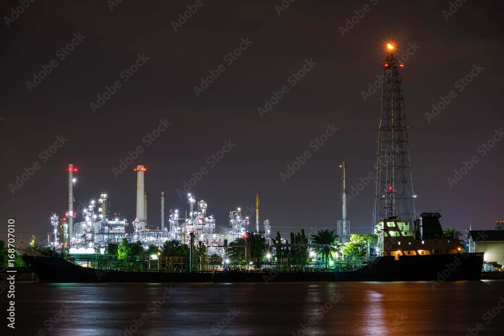 Oil refinery plant near river at twilight dusk