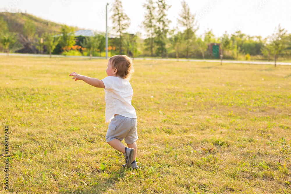 Summer, childhood and baby concept - little boy having fun in summer nature Summer, childhood and baby concept - little boy having fun in summer nature